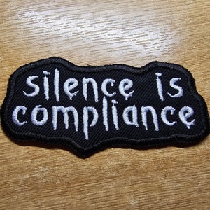 Tystnad är följsamhet Stryk-på broderad lapp Anarkistisk politik Feministisk vänsterlapp