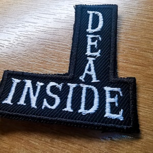 May include: Black and white embroidered patch with the words "INSIDE" and "DEAD" in a vertical L-shape.