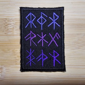 May include: A black fabric patch with purple embroidered runes. The runes are arranged in three rows. The runes are:  R, F, X, R, X, X, X, F, P, R.