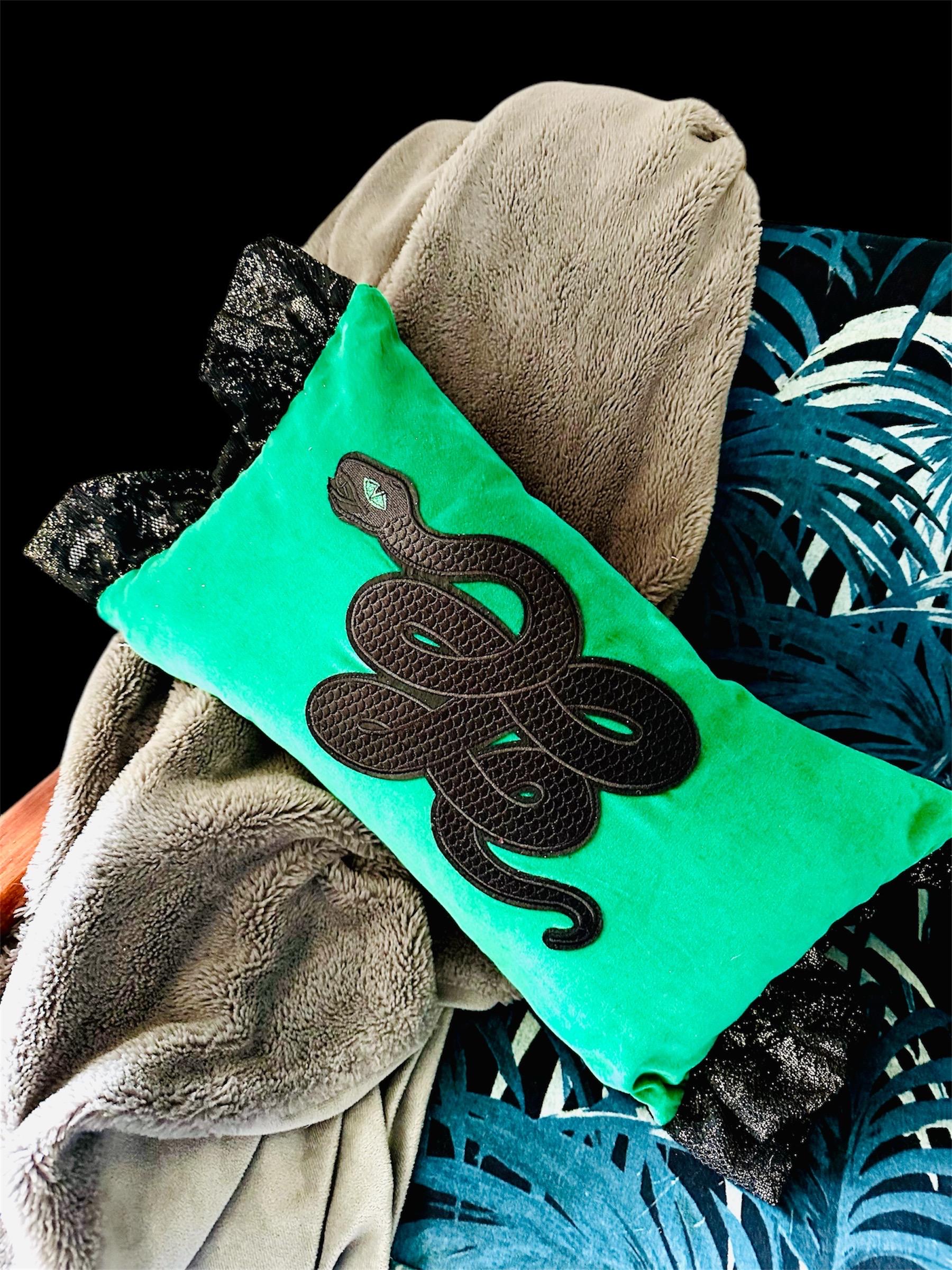 Green velvet snake appliquéd lumbar cushion with lace frill.