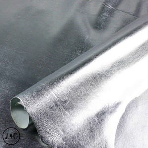 May include: Close-up of a silver leather sheet, folded over on itself, showing the texture of the leather.