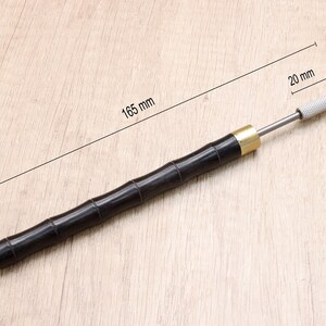 May include: A black wooden tool with a brass ferrule and a silver metal tip. The tool is 16.5 inches long and the tip is 20 mm long.