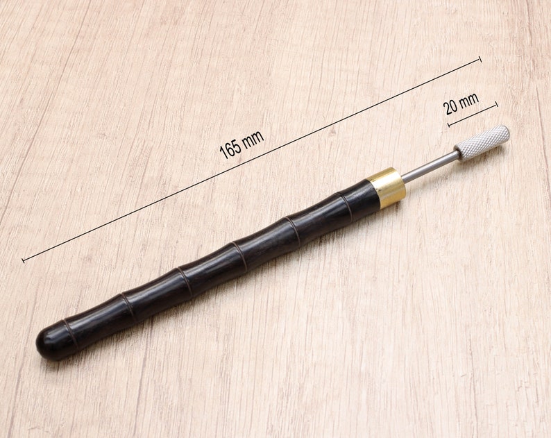 May include: A black wooden tool with a brass ferrule and a silver metal tip. The tool is 16.5 inches long and the tip is 20 mm long.