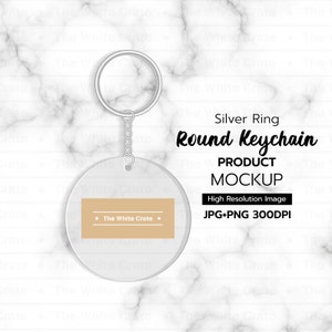 May include: A round keychain product mockup with a silver ring and chain. The keychain has a clear, circular design with a tan rectangle and the text "The White Crate." The image also includes the text "Round Keychain PRODUCT MOCKUP."