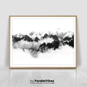 Könnte beinhalten: Schwarzweißfoto einer Bergkette mit Wolken. Die Berge sind im Hintergrund und die Wolken im Vordergrund. Das Bild ist aus der Vogelperspektive aufgenommen, mit Blick auf die Berge.