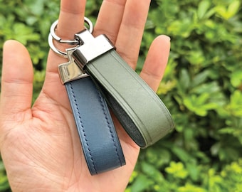 May include: Two leather keychains with silver key rings. One keychain is dark blue and the other is olive green.