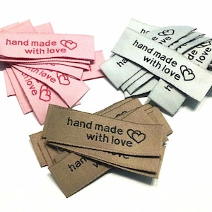 Könnte beinhalten: Ein Set aus drei Keramikbechern mit gesprenkelter, matter Oberfläche. Die Becher sind in Creme-, Hellgrau- und Dunkelgrautönen gehalten. Jeder Becher hat ein schlichtes, minimalistisches Design.