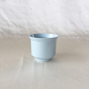 Peut inclure: Un pot en c&eacute;ramique bleu clair avec une base arrondie et un haut l&eacute;g&egrave;rement &eacute;vas&eacute;.