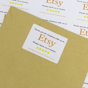May include: White sticker with the text "Thank you for shopping with us on Etsy. Please leave us a review." and five yellow stars. The sticker is on a brown paper envelope.