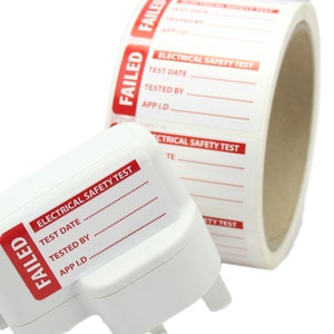 May include: A white electrical safety test sticker with the word "FAILED" in red. The sticker is attached to a white electrical adapter. The sticker has lines for the test date, tested by, and app ID.