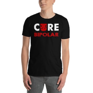 May include: Black t-shirt with the text "CORE BIPOLAR" in white and red. The word "CORE" has a graphic of a smiling and frowning face. The shirt is made of a soft material.
