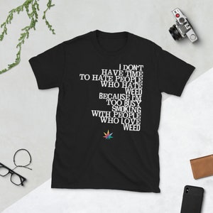 May include: Black t-shirt with white text that reads "I don't have time to hate people who hate weed because I'm too busy smoking with people who love weed". A colorful marijuana leaf is below the text.
