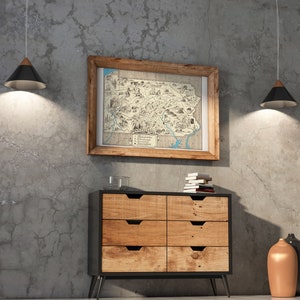 May include: A six-drawer dresser with a black frame and wooden drawers. The dresser is sitting on a concrete floor in front of a wall with two black pendant lights. A framed map of Pennsylvania hangs on the wall above the dresser. Two vases, one brown and one black, are on the floor to the right of the dresser.