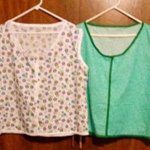 May include: Two sleeveless tops, one with a white background and a floral pattern, and the other a solid green color.