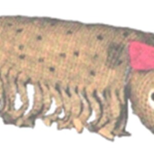 May include: A brown and tan woven caterpillar toy with a pink bow and white eyes. The toy has a smiling face.
