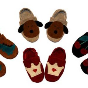 May include: Six pairs of felt slippers with different animal and design motifs. The slippers are brown, red, and black with various colors for the designs. The designs include a dinosaur, a dog, a crown, and cherries.
