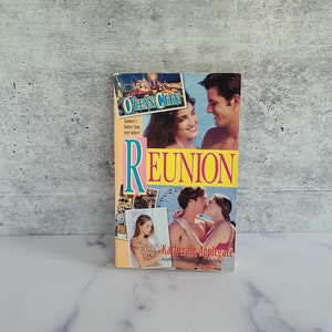 Puede incluir: Una novela de bolsillo titulada "Reunion" de Katherine Applegate. La portada presenta a una pareja besándose con un fondo de Ocean City, Maryland.