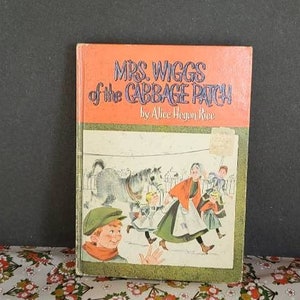 Puede incluir: Un libro infantil vintage titulado "Mrs. Wiggs of the Cabbage Patch" de Alice Hegan Rice. La portada presenta una ilustración de niños jugando en un paisaje nevado con un caballo y un perro.