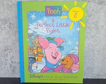 Puede incluir: Un libro verde con un sol amarillo en la portada. El libro se titula "A Perfect Little Piglet" y presenta a Winnie the Pooh y Piglet en una escena de invierno. El libro forma parte de Disney's Out & About With Pooh: A Grow and Learn Library, Volumen 2.