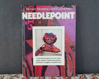 May include: A book titled "Better Homes and Gardens Needlepoint" with a colourful needlepoint design on the cover. The cover features a picture of a needlepoint tiger rug.