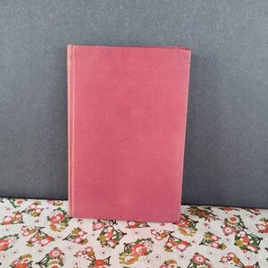 May include: A red hardcover book with a plain cover.