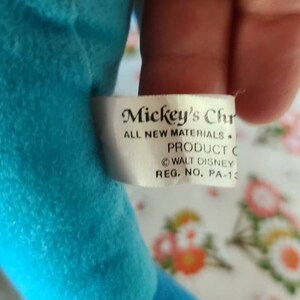 May include: A white tag with black text that reads "Mickey's Chr ALL NEW MATERIALS. PRODUCT C WALT DISNEY REG. NO. PA-13"