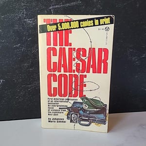 Puede incluir: La portada del libro El Código César presenta un diseño de alambre de púas y una foto en blanco y negro de un hombre con uniforme militar. El título del libro está en letras rojas y negras. El texto de la portada dice "Más de 5.000.000 de copias impresas" y "Primera publicación estadounidense de un best-seller internacional".