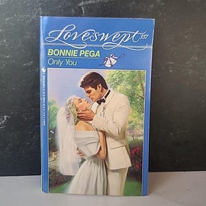 May include: A paperback book titled "Loveswept 357" by Bonnie Pega, "Only You." The cover features a romantic illustration of a bride and groom embracing. The book has a blue cover with white text and a wedding bell graphic.