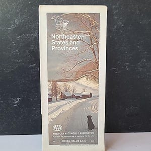 May include: A vintage AAA travel map titled "Northeastern States and Provinces." The cover features a winter landscape with a snowy road, trees, and a silhouette of a dog. The AAA logo and text are at the bottom.