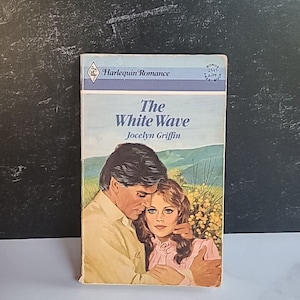 May include: A Harlequin Romance paperback book titled "The White Wave" by Jocelyn Griffin. The cover features a couple embracing in a field of flowers.