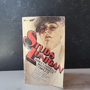 May include: A paperback book cover with a red and white title "Studs Lonigan" by James T. Farrell. The cover features a black and white illustration of a man with a cigarette in his mouth.