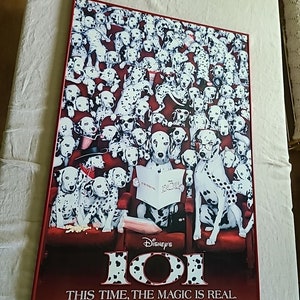 May include: A red and white poster advertising the movie 101 Dalmatians. The poster features a large image of a Dalmatian dog sitting in a movie theater seat with a book titled "101 Dalmatians" in its paws. The poster also includes the text "Disney's 101 Dalmatians This Time, The Magic Is Real. Thanksgiving 1996."