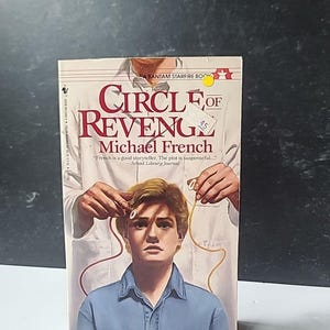 以下が含まれることがあります： マイケル・フレンチ著「Circle of Revenge」というタイトルのペーパーバック。表紙には、青いシャツを着た若い男性が、白いコートを着た人に持たれた耳の近くにワイヤーが描かれています。この本はBantam Starfire Bookです。