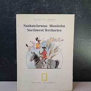 May include: A vintage National Geographic book cover with the text "CLOSE-UP: CANADA" and the names of Canadian provinces. The cover features an illustration of a person on horseback, wheat, and flying birds. The National Geographic logo is at the bottom.