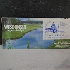 Puede incluir: Un mapa de carreteras del estado de Wisconsin con un paisaje escénico en la portada, con un río y árboles. El texto "WISCONSIN regions of delight" se muestra de forma destacada. El texto adicional incluye "Tony Staskunas State Representative" y "2001-2002 Edition Official State Highway Map."