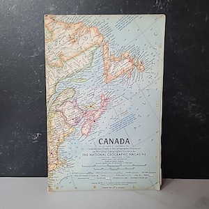 Puede incluir: Un mapa antiguo de Canadá de The National Geographic Magazine. El mapa presenta información geográfica detallada, incluyendo costas, ciudades y cuerpos de agua. El mapa está impreso en papel envejecido con una escala de 810.400 o 64,37 kilómetros por pulgada.