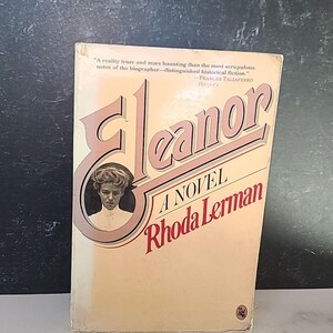 May include: A vintage copy of "Eleanor A Novel" by Rhoda Lerman. The book's cover is a light peach colour, with the title in a pink, stylized font. A portrait of a woman is in a circular frame. Includes a quote from Frances Taliaferro.