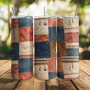 May include: Three stainless steel tumblers with lids and straws. The tumblers feature a patchwork design with denim, paisley, and lace patterns in shades of blue, red, and brown. Each tumbler has a decorative charm.