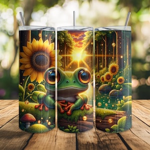 May include: Three stainless steel tumblers with a whimsical design. Each tumbler features a vibrant illustration of a cartoon frog with large eyes, set against a backdrop of sunflowers, a forest, and a sunset.
