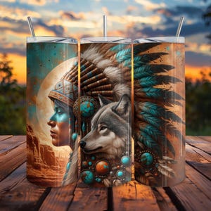 Pode incluir: Três canecas isoladas de aço inoxidável com um design nativo americano e lobo. O design apresenta o perfil de uma pessoa com pintura facial turquesa e um lobo, contra um fundo de pôr do sol. As canecas têm uma palhinha e uma tampa.