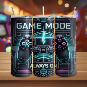 May include: A black tumbler with a gaming theme. The design features a neon-style controller, a lightning bolt, and the words "GAME MODE" and "ALWAYS ON." The tumbler has a silver straw and lid.