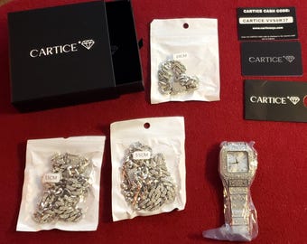 A collection of Cartice brand fashion jewelry, including an iced-out watch and several cuban link chains. ( Note: costume jewelry)
