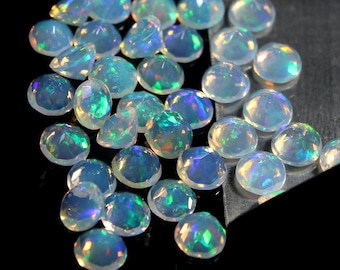 May include: A collection of iridescent white opal gemstones, each with a unique pattern of color and light.