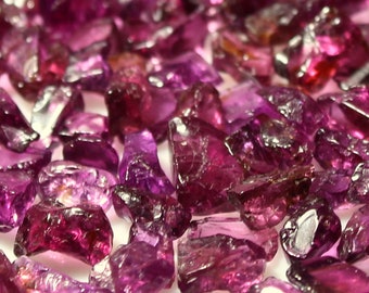 May include: A collection of loose, faceted, pink and purple gemstones. The gemstones are various sizes and shapes.