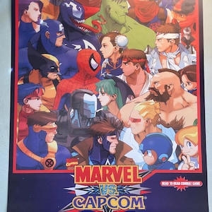 May include: A poster featuring a collage of Marvel and Capcom characters. The poster has a dark blue background with the text "MARVEL vs. CAPCOM" and "CLASH OF SUPER HEROES". The characters include Spider-Man, Wolverine, and Captain America.