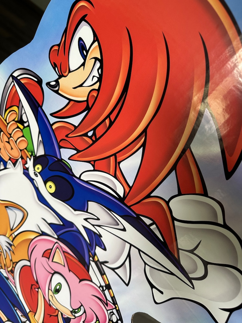 May include: A red and white cartoon character with a red mohawk and blue eyes. The character is in a fighting pose with a blue and white wing behind it. The character is surrounded by other cartoon characters.