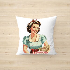May include: A white pillow with a vintage illustration of a woman in a blue and white polka dot dress holding a pitcher and a bowl of popcorn. The woman is smiling and has a red bow in her hair.