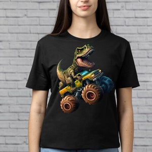 May include: Black t-shirt with a graphic print of a green dinosaur driving a yellow monster truck.