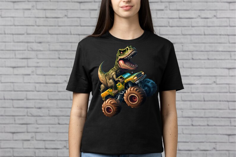 May include: Black t-shirt with a graphic print of a green dinosaur driving a yellow monster truck.