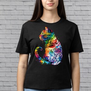 May include: A black t-shirt with a colorful, abstract design of a cat. The cat is sitting with its tail curled around its body. The design is made up of swirls and dots in shades of blue, green, yellow, orange, red, and purple.